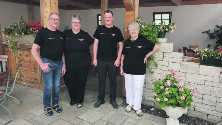 Zwei Frauen und zwei Männer im Außenbereich eines Restaurants.