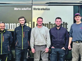 Fünf Personen vor ihrem Firmenlogo