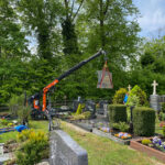 Einsatz eines Raupenkrans mit einem 500-kg-Grabstein am Haken.