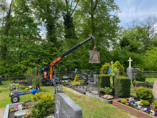 Einsatz eines Raupenkrans mit einem 500-kg-Grabstein am Haken.