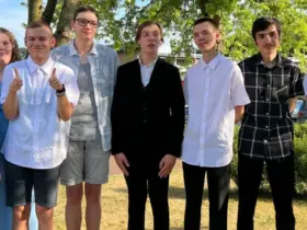 Gruppenfoto der Absolventen: Die frisch gebackenen Schulabgänger stehen gemeinsam im Freien auf dem Schulgelände.