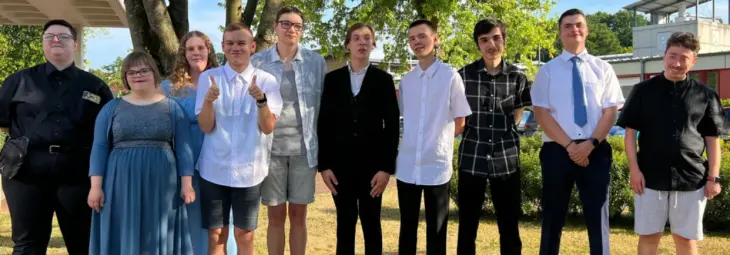 Gruppenfoto der Absolventen: Die frisch gebackenen Schulabgänger stehen gemeinsam im Freien auf dem Schulgelände.