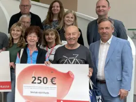 Landrat Alexander Tritthart (rechts) gratuliert den erfolgreichsten Stadtradlern in Erlangen-Höchstadt. Darunter das Team des Skiclub ASV Forth (vorne), das sich über 150 Euro freuen durfte.