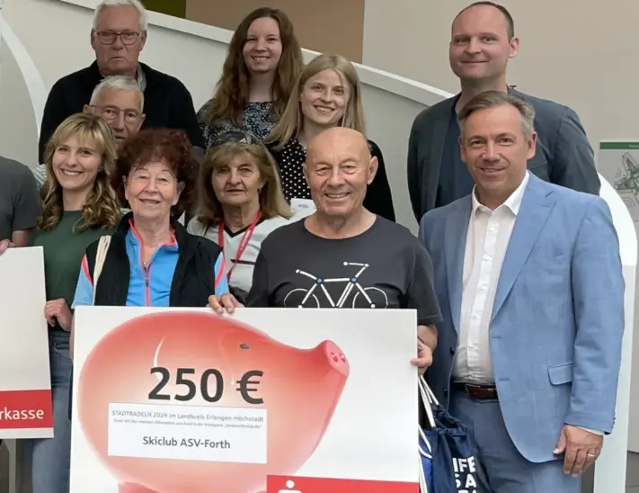 Landrat Alexander Tritthart (rechts) gratuliert den erfolgreichsten Stadtradlern in Erlangen-Höchstadt. Darunter das Team des Skiclub ASV Forth (vorne), das sich über 150 Euro freuen durfte.