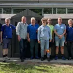 Mitarbeiter und ein jugendlicher Helfer des Blindeninstituts Rückersdorf zusammen mit den Mitgliedern des Lions Club Lauf vor dem fast fertigen Fahrradschuppen.