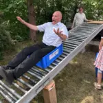 Pfarrer Bernhard Winkler wagt sich auf die Rollrutsche.