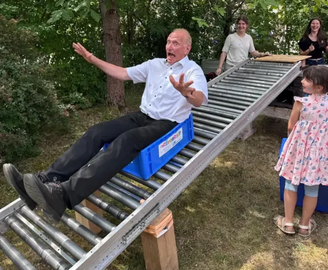 Pfarrer Bernhard Winkler wagt sich auf die Rollrutsche.