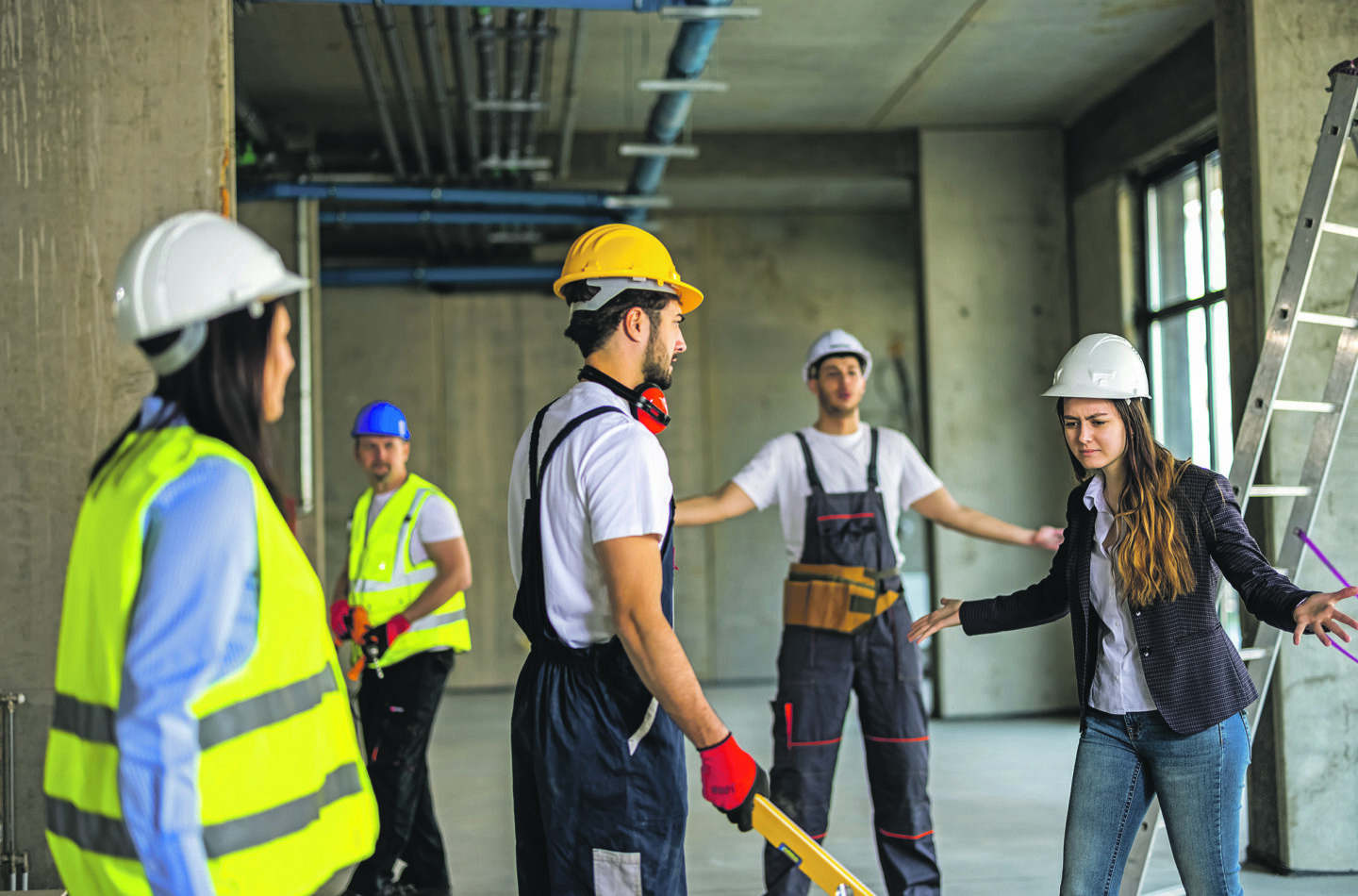 Mehrere Menschen mit Helmen auf einer Baustelle