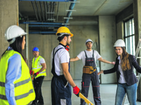 Mehrere Menschen mit Helmen auf einer Baustelle