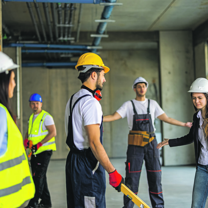 Mehrere Menschen mit Helmen auf einer Baustelle