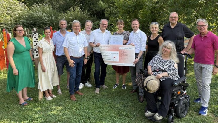 Große Freude bei der Preisverleihung: Bezirkstagspräsident Peter Daniel Forster (5. von rechts) überreicht Alina Stampfl (6. von rechts), Projektleiterin der inklusiven Streuobstwiese, den symbolischen Scheck.