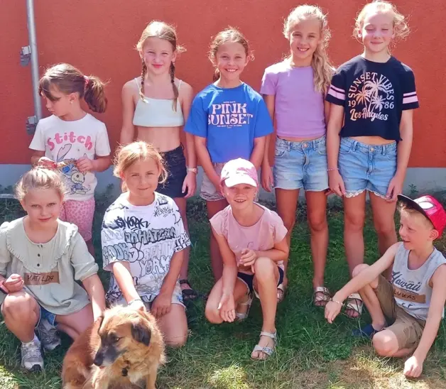 Die Ferienkinder, die das Tierheim Feucht besuchten, posieren gemeinsam mit einem Hunde für ein Erinnerungsfoto.