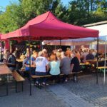 Bei bestem Spätsommerwetter füllten sich die Bierzeltgarnituren unter den Pavillons schnell: Nachbarn und Bewohner der Asylunterkunft kamen bei Essen und Trinken ins Gespräch.