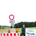Andreas Oppel führt den Kfz- und Landtechnikbetrieb Oppel in Gersdorf. Zum Unternehmen gehören außerdem eine ENI-Tankstelle sowie ein Laden mit Back- und Kaffeeshop.
Für den Fototermin wählte er mit Absicht die Kreuzung bei Winn. Damit möchte er darauf aufmerksam machen, dass der Betrieb und die Tankstelle trotz der Baustelle erreichbar sind. Die Beschilderung findet er sehr irreführend, da viele Verkehrsteilnehmer sich nicht trauen, an einem Sperrschild vorbeizufahren. Tatsächlich kann die Straße bis einschließlich der Abzweigung nach Weigenhofen und damit bis nach Lauf ohne Einschränkungen genutzt werden.