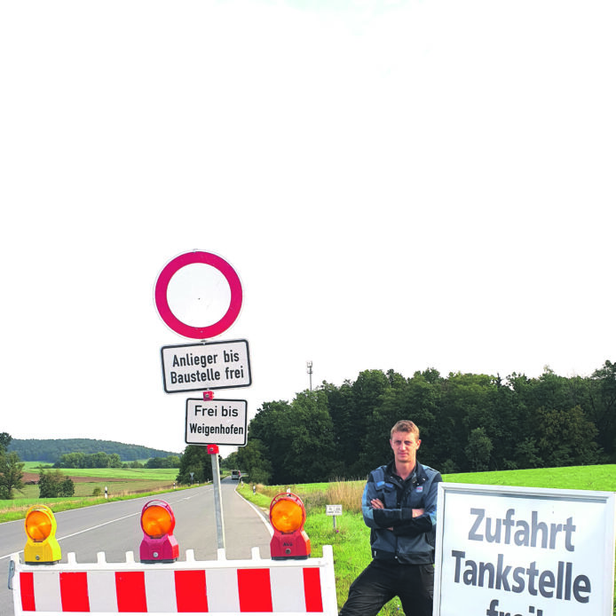 Andreas Oppel führt den Kfz- und Landtechnikbetrieb Oppel in Gersdorf. Zum Unternehmen gehören außerdem eine ENI-Tankstelle sowie ein Laden mit Back- und Kaffeeshop.
Für den Fototermin wählte er mit Absicht die Kreuzung bei Winn. Damit möchte er darauf aufmerksam machen, dass der Betrieb und die Tankstelle trotz der Baustelle erreichbar sind. Die Beschilderung findet er sehr irreführend, da viele Verkehrsteilnehmer sich nicht trauen, an einem Sperrschild vorbeizufahren. Tatsächlich kann die Straße bis einschließlich der Abzweigung nach Weigenhofen und damit bis nach Lauf ohne Einschränkungen genutzt werden.