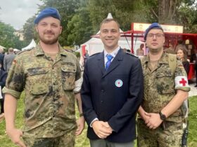 Jörn Rechenburg (Mitte) von der Wasserwacht Weißenbrunn beim Bürgerfest in Bonn. Umrahmt wird er von zwei Vertretern des Bundeswehr-Sanitätsdienstes.