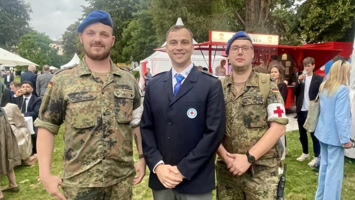 Jörn Rechenburg (Mitte) von der Wasserwacht Weißenbrunn beim Bürgerfest in Bonn. Umrahmt wird er von zwei Vertretern des Bundeswehr-Sanitätsdienstes.