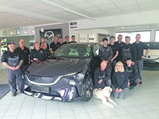 Mehrere Personen im Autohaus bei einem Neuwagen