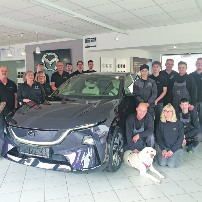 Mehrere Personen im Autohaus bei einem Neuwagen