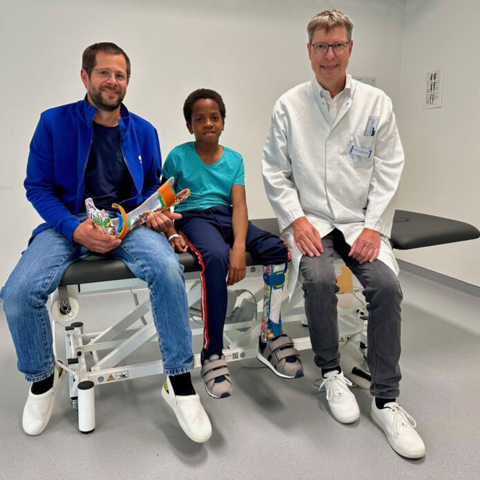 Sebastian Grasruck von der Ortho-Technik Rummelsberg (links) und Chefarzt Dr. Michael Wachowsky (rechts) zusammen mit Gabriel nach Abschluss der Behandlung.