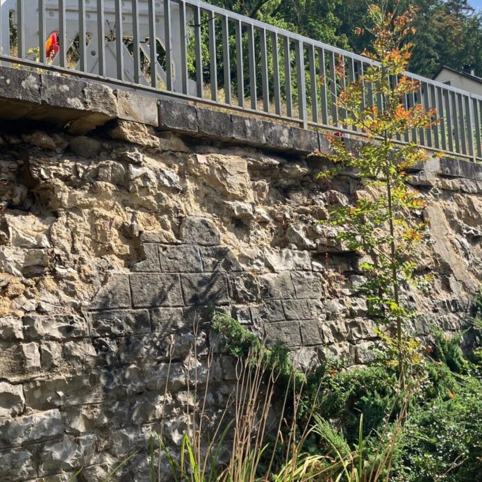 Die Stützmauer an der Kreisstraße AS 38 in Oed weist markante Schäden auf und soll erneuert werden.