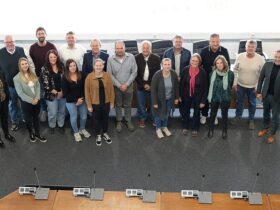 Circa 15 Personen sind stehend auf dem Foto zu sehen.