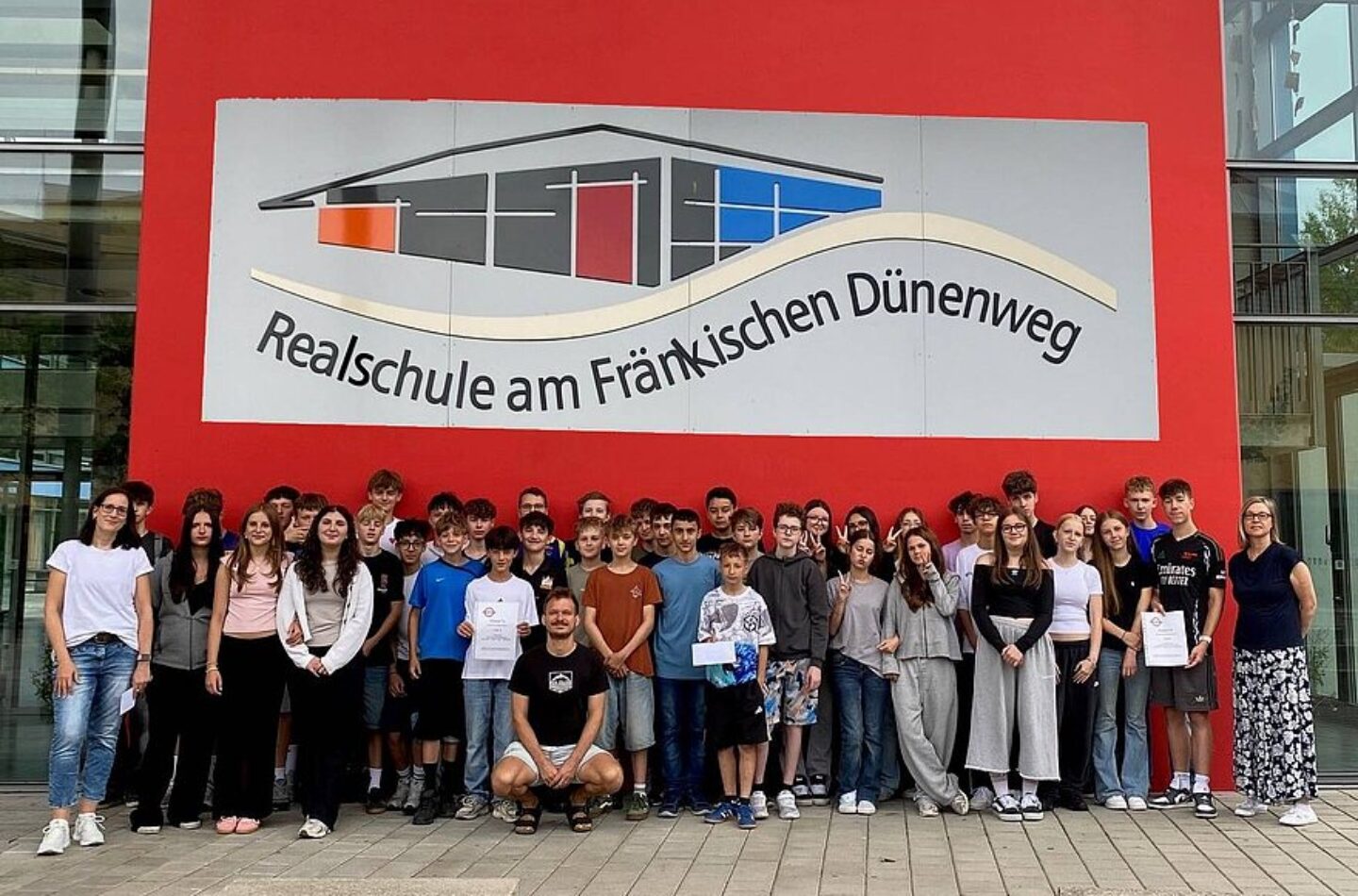 Schüler zeigen sich vor einer Wand