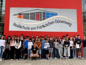 Schüler zeigen sich vor einer Wand