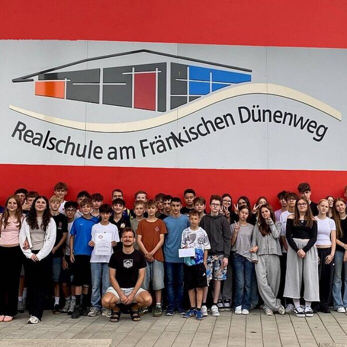 Schüler zeigen sich vor einer Wand